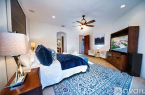 La Quinta house for rent - A bedroom with a large bed and a flat screen TV.