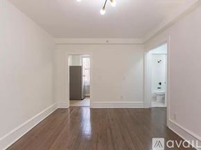 Merchantville apartment for rent - A room with wooden floors and white walls, with a door on the right side.
