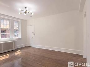Merchantville apartment for rent - A room with wooden floors and a window with a view of a building outside.