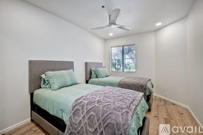 Oceanside apartment for rent - A bedroom with two beds and a ceiling fan.