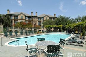 Irving apartment for rent - A pool area with chairs and a building in the background.