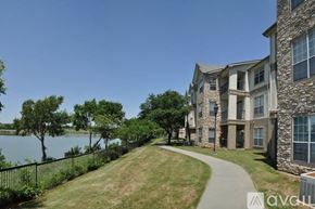 Fort Worth apartment for rent - A modern apartment building with a walkway and a body of water in the background.