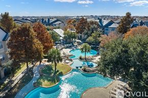 Fort Worth apartment for rent - A bird's eye view of a pool surrounded by trees and houses.