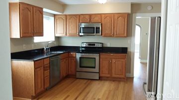 Royal Oak apartment for rent - A kitchen with wooden cabinets and black countertops.
