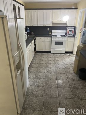 Miami Gardens house for rent - A kitchen with white appliances and cabinets.
