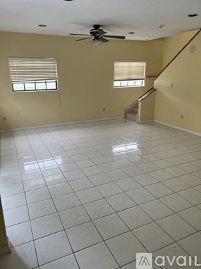 Miami Gardens house for rent - A living room with a fan and a staircase.
