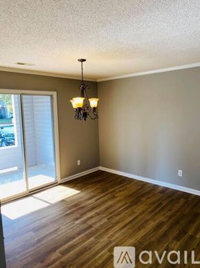 Greenville condo for rent - A room with dark wood flooring and a window with blinds.