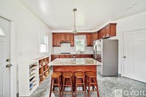 Quincy apartment for rent - A kitchen with wooden cabinets and a marble island.