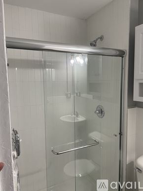 Highland Park apartment for rent - A shower with a glass door and a metal handle.