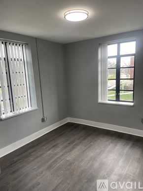 Highland Park apartment for rent - A room with a window and a wall-mounted light fixture.