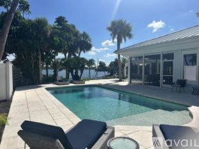 Nokomis house for rent - A pool surrounded by trees and a white fence.
