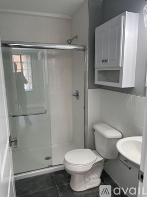 Highland Park apartment for rent - A white toilet sits in a bathroom next to a walk-in shower.