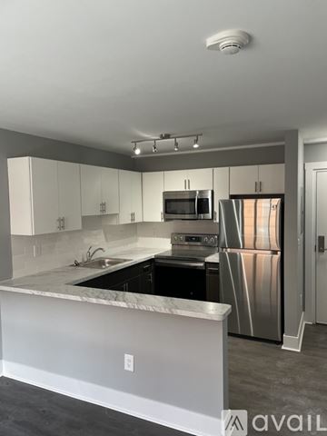 Highland Park apartment for rent - A modern kitchen with stainless steel appliances and a marble countertop.