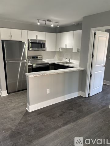 Highland Park apartment for rent - A kitchen with a white island and stainless steel appliances.