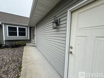 Wausau apartment for rent - A modern living room with a fireplace and a dining table set for two.