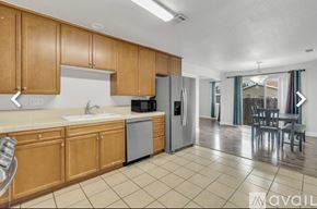 Sacramento house for rent - A kitchen with wooden cabinets and a refrigerator.