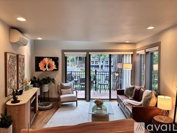Lake Oswego house for rent - A living room with a couch, chair, and a table with a vase of flowers on it.