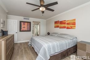 Clearwater condo for rent - A bedroom with a bed, dresser, and ceiling fan.