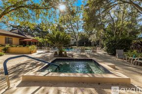 Clearwater condo for rent - A sunny backyard with a pool and patio furniture.