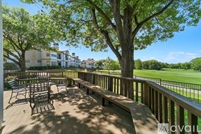 Plano apartment for rent - A deck with a table and chairs overlooking a green field.