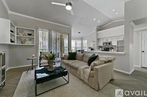 Plano apartment for rent - A living room with a couch, a coffee table, and a ceiling fan.
