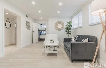 Miami house for rent - A modern living room with a grey couch and a white coffee table.