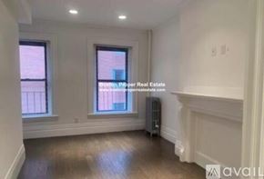 Boston apartment for rent - A room with wooden floors and white walls, with a window and a radiator.