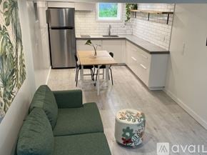 Portland house for rent - A kitchen with a green couch and a wooden table.