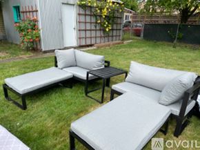Portland house for rent - A black and white outdoor furniture set is on a grassy area.
