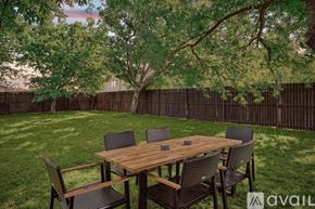 Grand Prairie house for rent - A wooden table with chairs is set up in a grassy backyard.