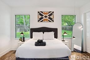 Grand Prairie house for rent - A bedroom with a large bed and a painting on the wall.