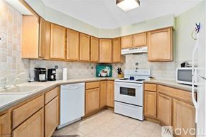 Wildwood condo for rent - A kitchen with wooden cabinets and white appliances.