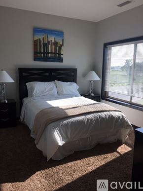 Mankato apartment for rent - A bedroom with a large bed and a painting on the wall.