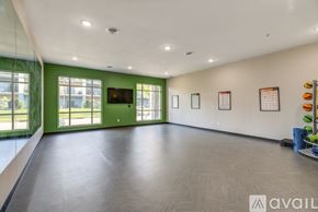 Mankato apartment for rent - A spacious room with a green door and a flat screen TV mounted on the wall.