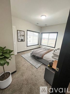 Mankato apartment for rent - A bedroom with a bed, a plant, and a picture on the wall.