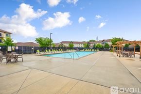 Mankato apartment for rent - A large outdoor swimming pool surrounded by a concrete patio and lounge chairs.
