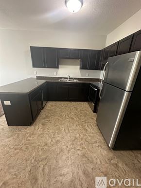 Mankato apartment for rent - A kitchen with black cabinets and a silver refrigerator.
