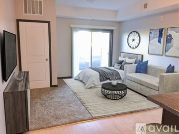 Mankato apartment for rent - A living room with a grey couch and a large window.