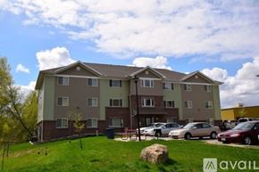 Mankato apartment for rent - Apartment complex with a grassy area in front and cars parked in the driveway.