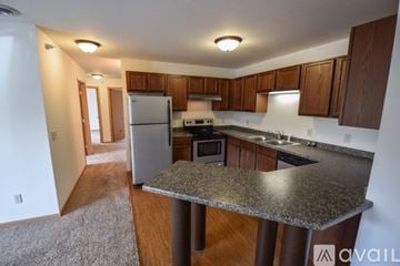 Mankato apartment for rent - A kitchen with a granite countertop and wooden cabinets.