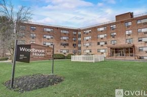 Ewing Township apartment for rent - A sign for Woodbrook House stands in front of a brick building.