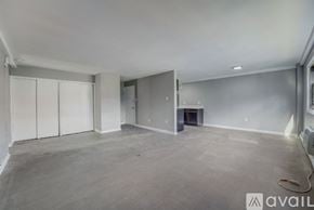 Ewing Township apartment for rent - A spacious empty room with a fireplace and a wall-mounted TV.