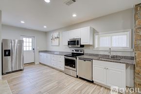Washington apartment for rent - A kitchen with white cabinets and a stone wall.