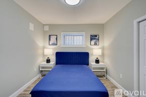 Washington apartment for rent - A bedroom with a blue bed and two white nightstands.