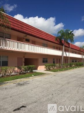 Lauderhill apartment for rent - A building with a red roof and a balcony.