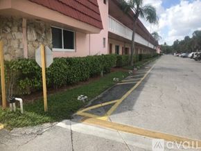 Lauderhill apartment for rent - A street with a stop sign and a building with a red roof.