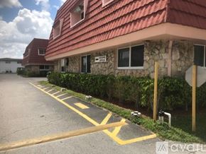 Lauderhill apartment for rent - A parking lot with a yellow line and a building in the background.