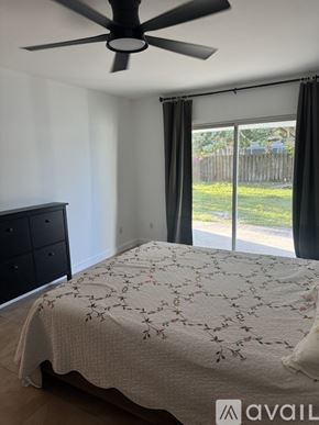 Port St. Lucie house for rent - A backyard with a bench and a tree with lights.