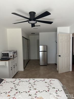 Port St. Lucie house for rent - A white tiled bathroom with a bathtub and a door.