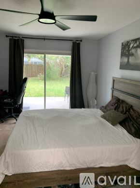 Port St. Lucie house for rent - A bedroom with a bed, a ceiling fan, and a picture on the wall.